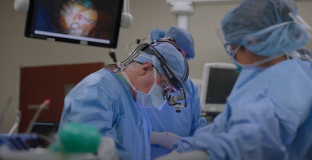 Physician and care team performing surgery in an operating room