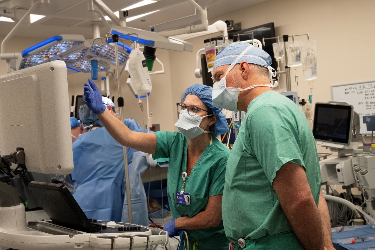 Physicians conferring over a monitor while in the operating room