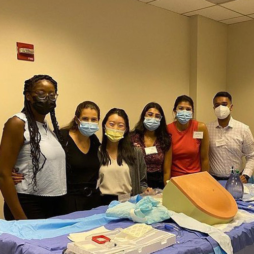 Northwestern Medicine interns standing around a table with medical equipment.