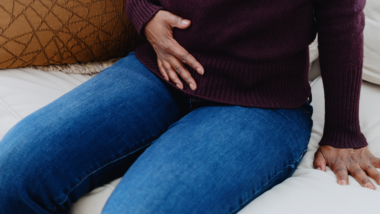 Person holding the lower right side of their stomach.