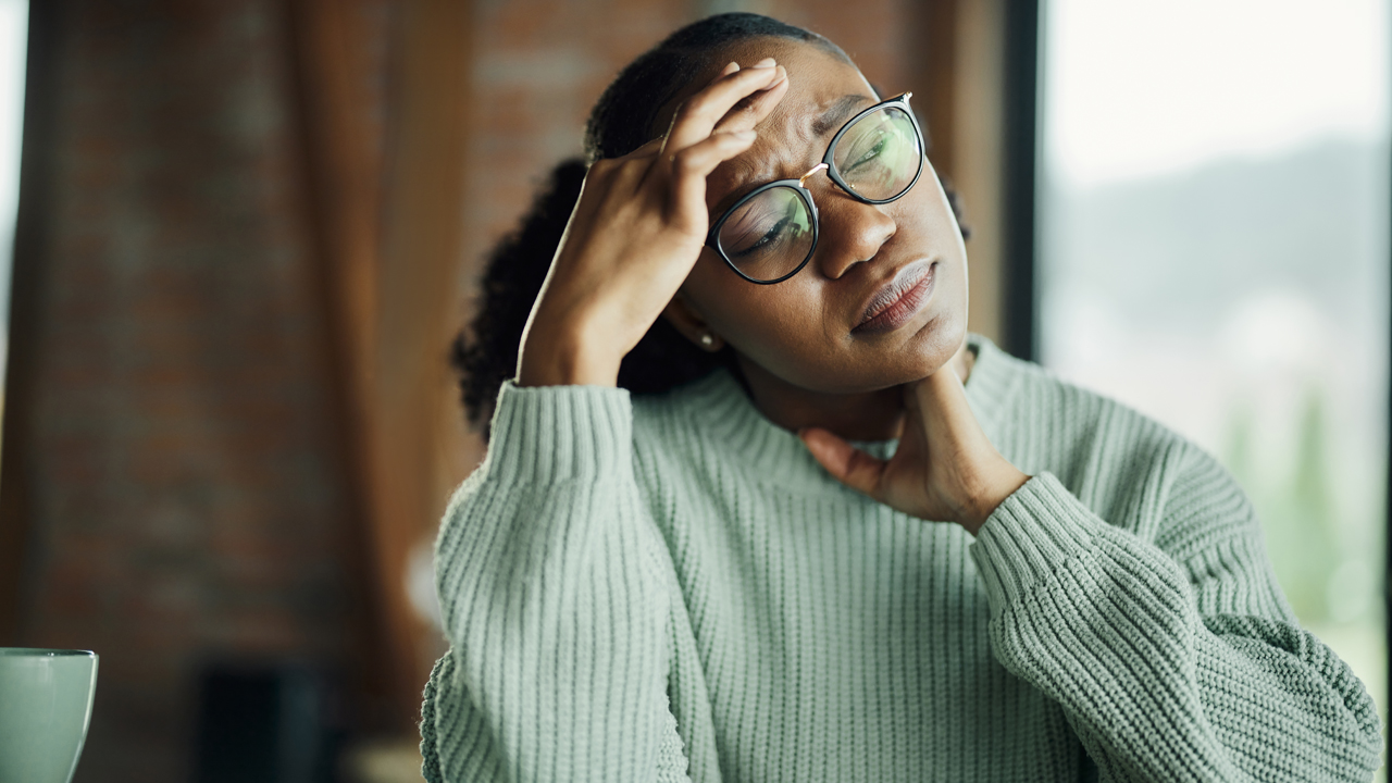 Person pressing their forehead in pain.