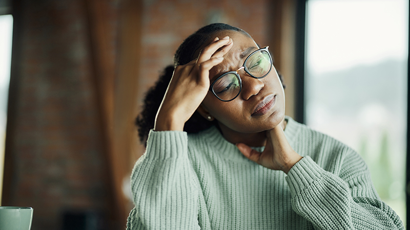 Person pressing their forehead in pain.
