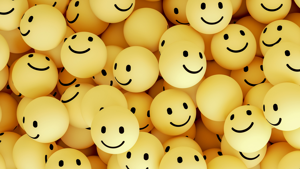 Pile of yellow, three dimensional happy face emojis.