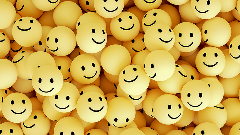 Pile of yellow, three dimensional happy face emojis.