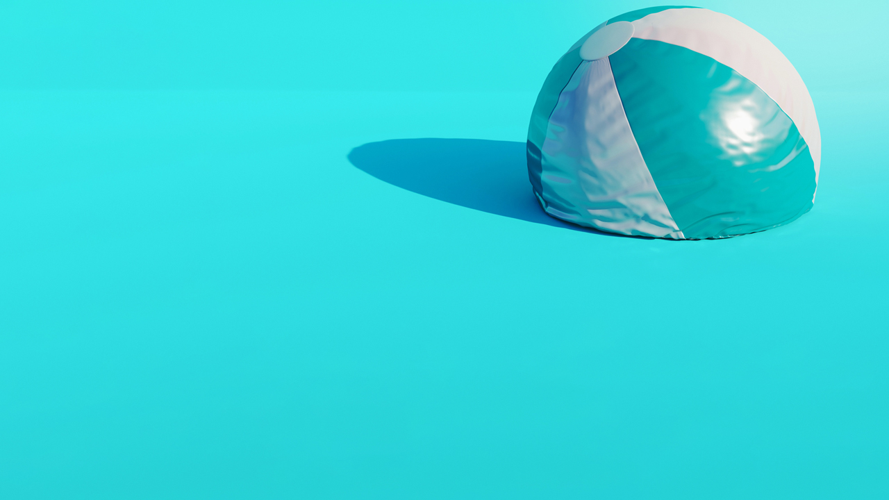 Blue and white beachball that is half deflated.