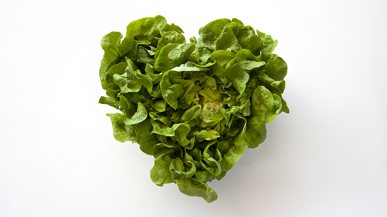 Overhead image of lettuce bunched in the shape of a heart.