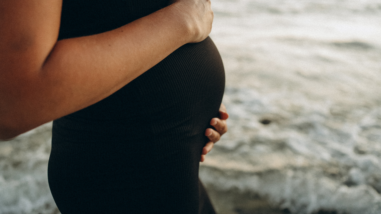 Pregnant person on the beach.