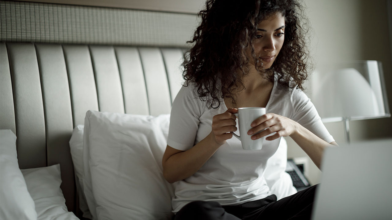 woman using her laptop on the bed