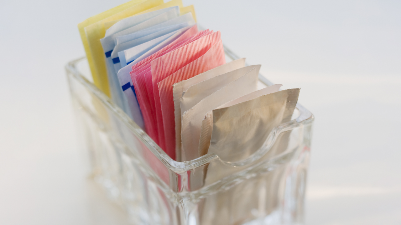 A close-up of sugar and artificial sweetener packets.