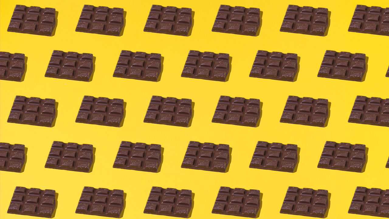 Multiple dark chocolate bars on a yellow background.