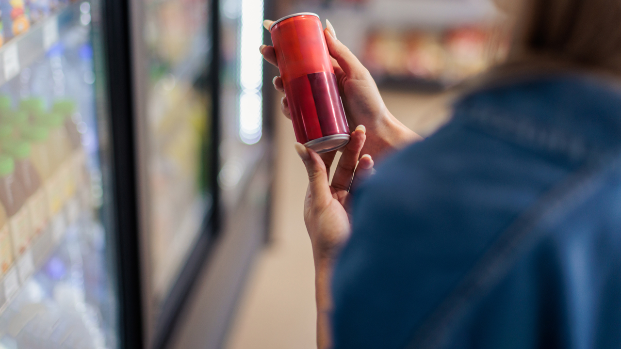 Person holding an energy drink. 