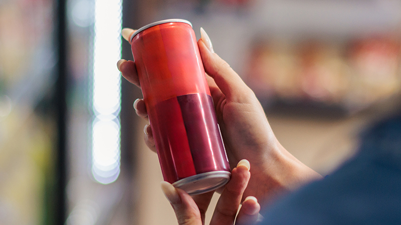 Person holding an energy drink. 