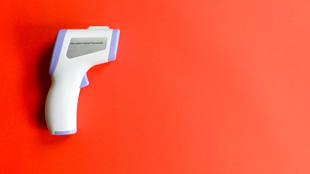 Digital Non-Contact Forehead Thermometer Laser on red background.