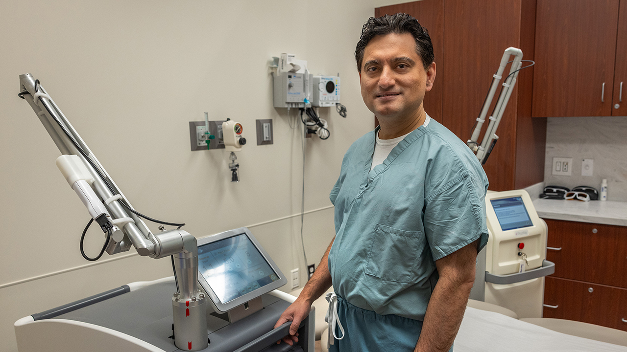 Murad Alam, MD, a dermatologist at Northwestern Medicine, stands by the machine that removes tattoos.