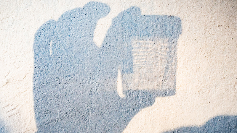 Shadow of someone holding a urine sample.  