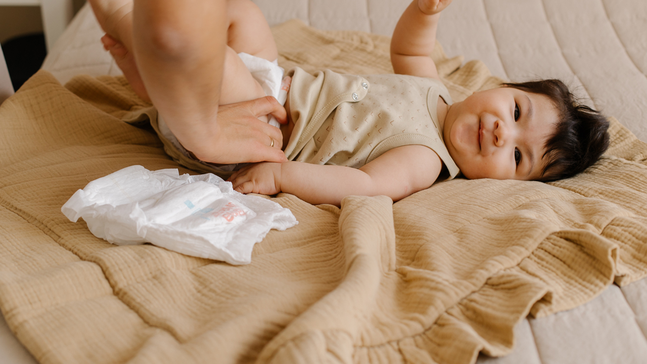 Baby having their diaper changed on a blanket.