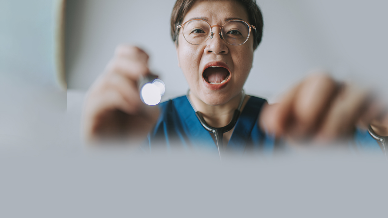A physician about to look into a patient’s mouth.