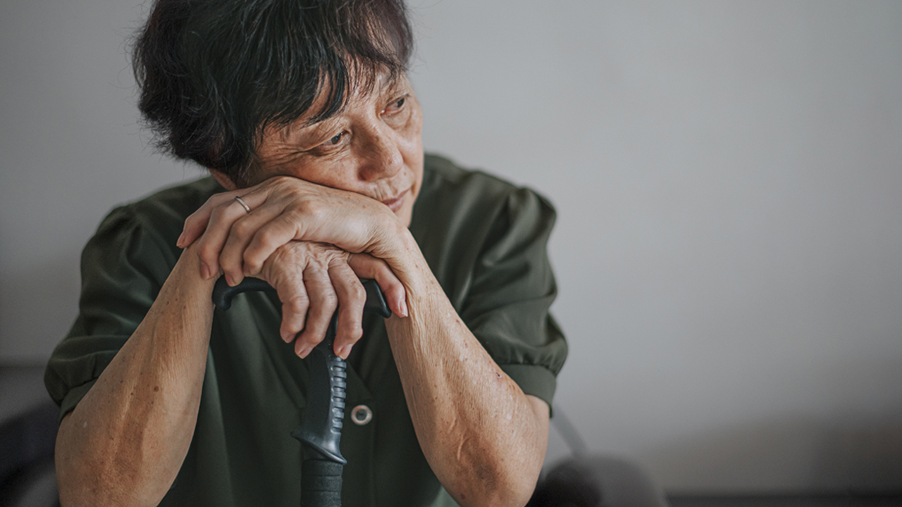 Person resting face on hands looking sad.