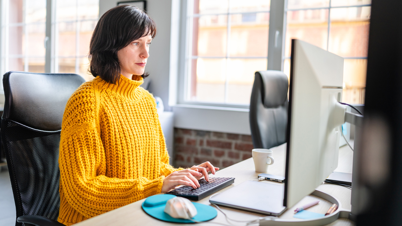 A person sitting in front of a desktop computer.