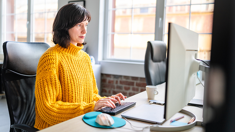A person sitting in front of a desktop computer.