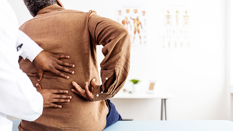 Doctor's hands examining patient's lower back.