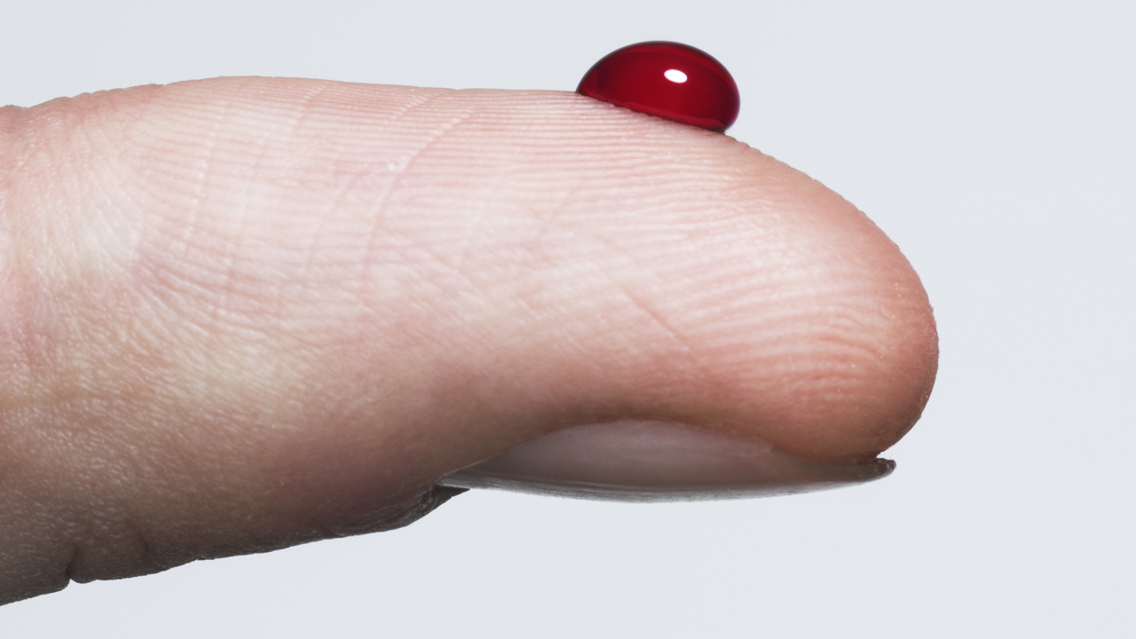 A bead of blood on a fingertip.