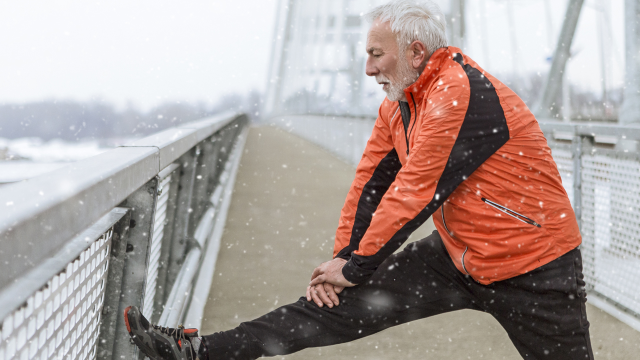 person with one leg stretched out with snow falling