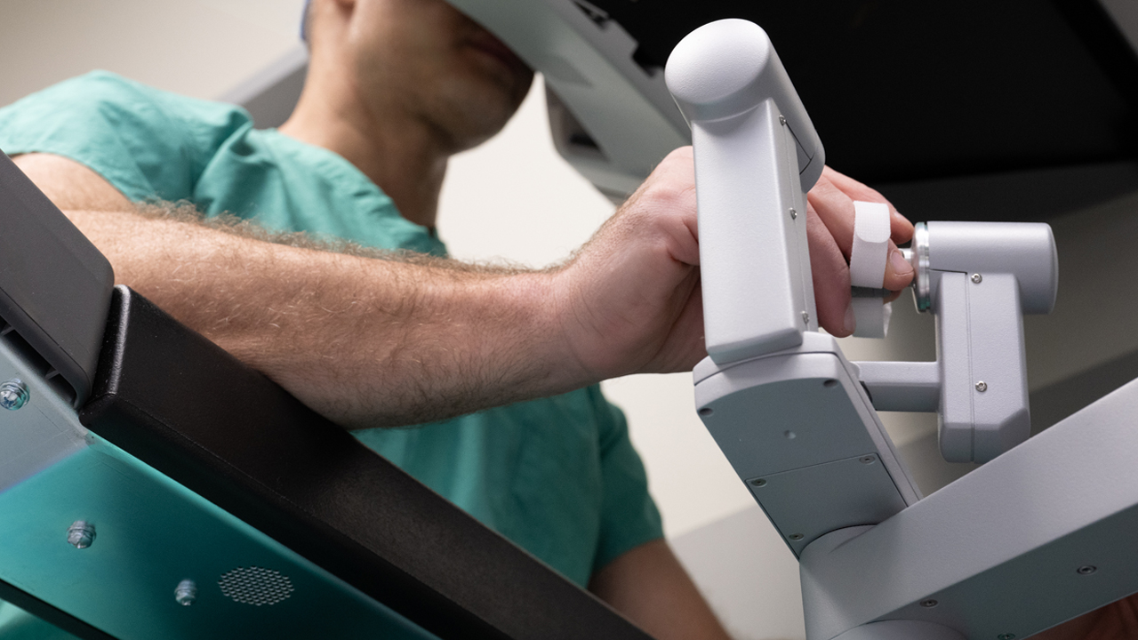 A surgeon using the hand controls of a da Vinci robot.