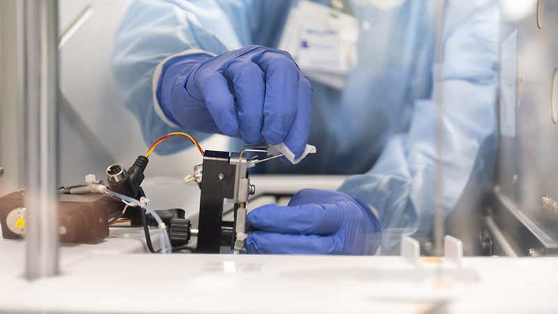 The gloved hands of a Northwestern Medicine clinician-scientist clean laboratory equipment.