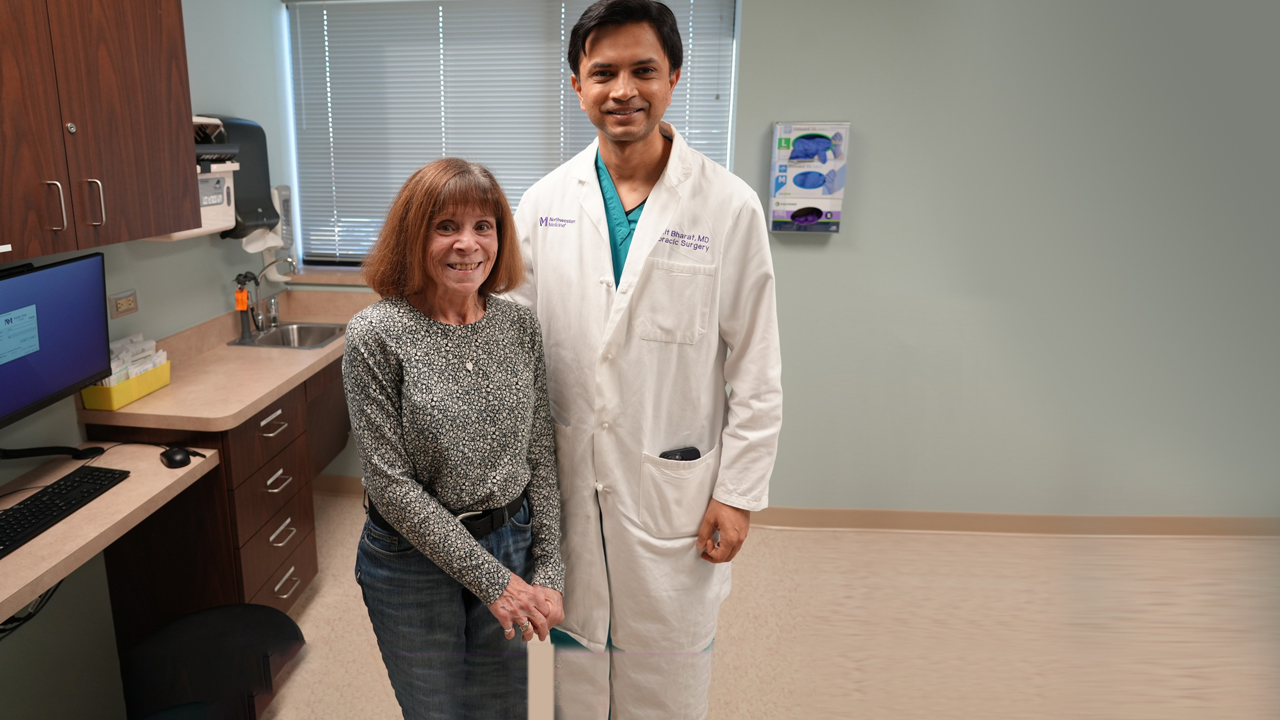 Kathie Schultz wearing a black-and-white shirt standing next to Ankit Bharat, MD, wearing a white physician's coat.