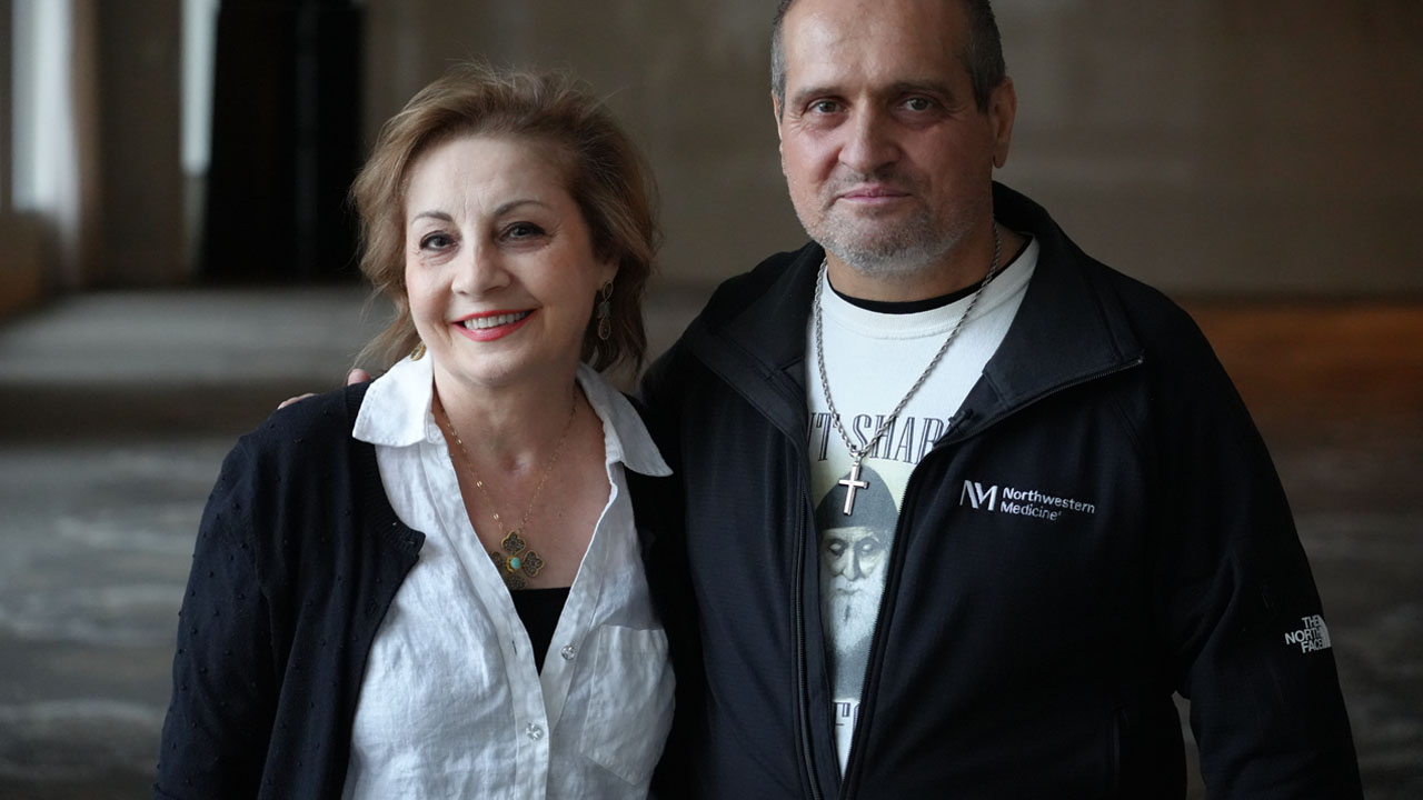 Two people posed with arms around each other and smiling. 