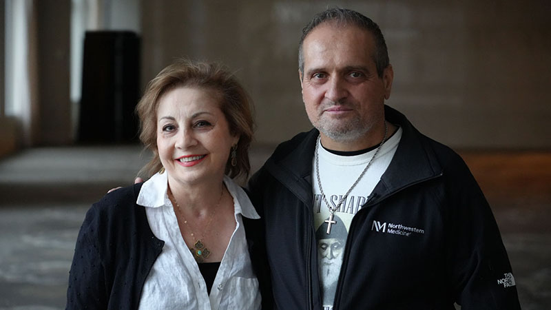 Two people posed with arms around each other and smiling. 