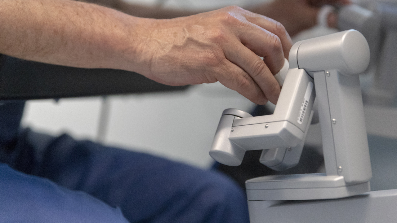 A hand on a piece of technology in a surgical room. 