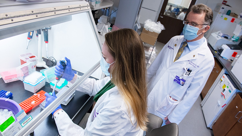 2 people in clinical uniforms in a lab