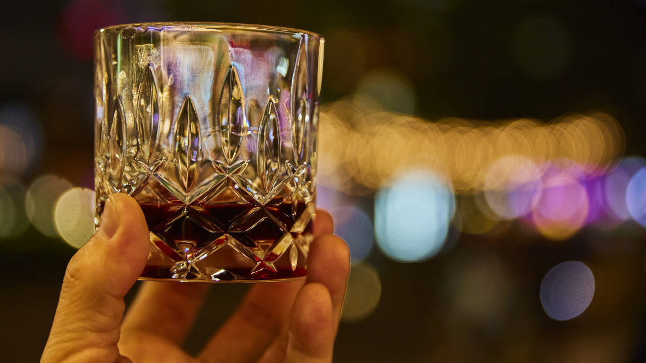Liquor in a glass with city background.