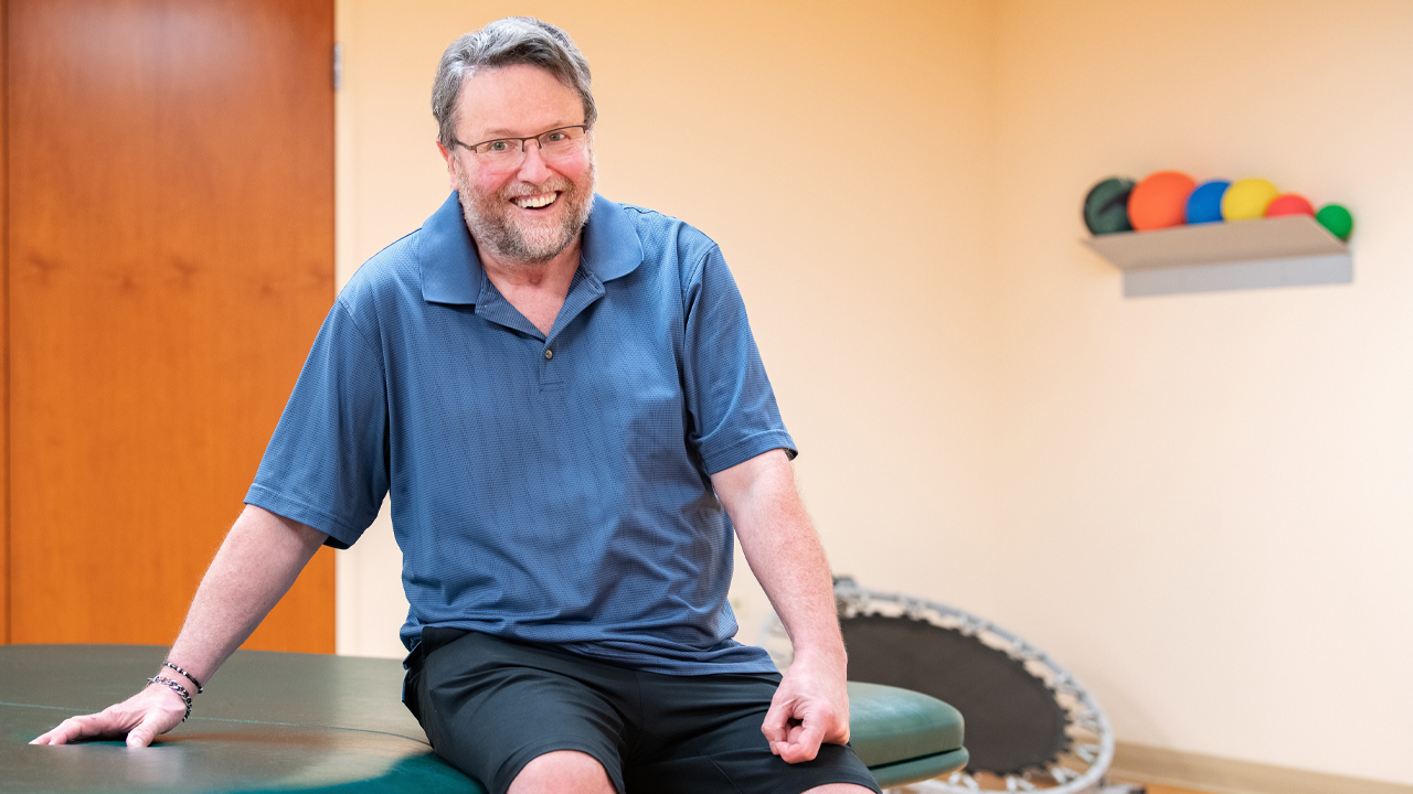 Neels de Coning sitting on a rehab table.