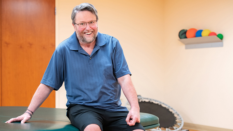 Neels de Coning sitting on a rehab table.
