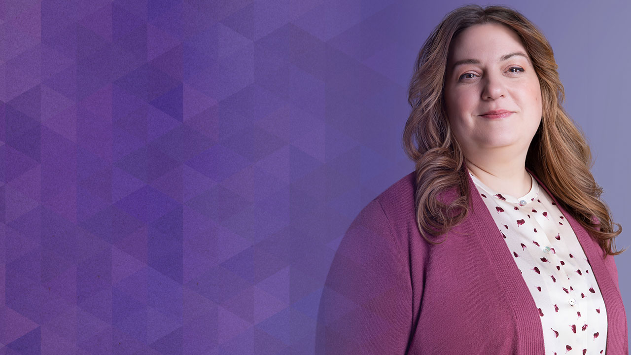 Robin standing in front of purple background