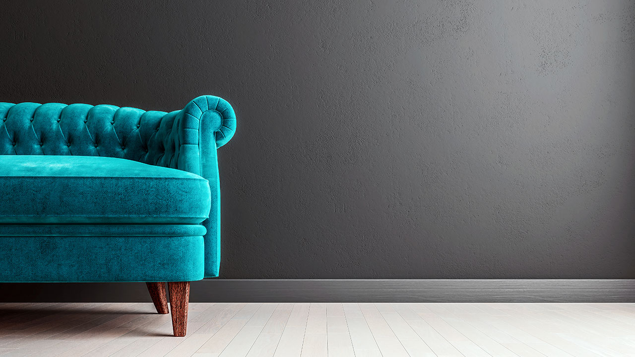 Living room dark grey wall with turquoise velvet sofa, with free space to the right