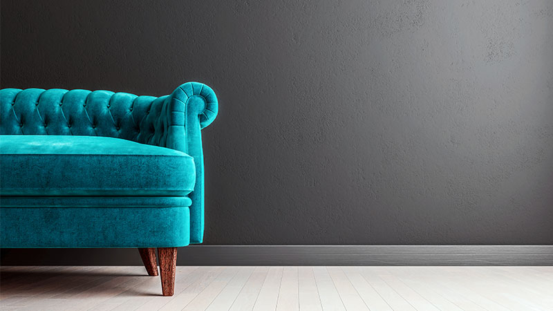 Living room dark grey wall with turquoise velvet sofa, with free space to the right