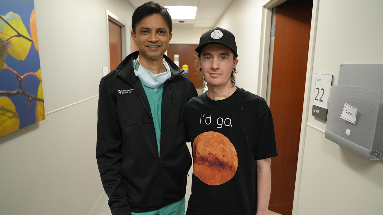 Ankit Bharat, MD, and David “Davey” Bauer pose in a hospital hallway. 