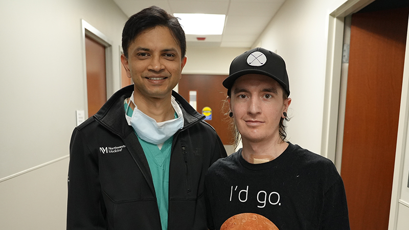 Ankit Bharat, MD, and David “Davey” Bauer pose in a hospital hallway. 