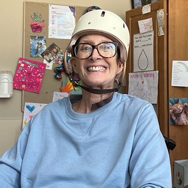 Linda Budziak wearing a helmet in a hospital room.