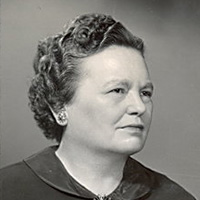Black and white portrait of Augusta Webster, MD. She is a white woman with short wavy hair and is wearing a black dress. 