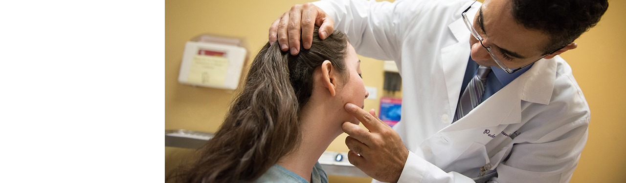 Dermatologist examining a woman's face 