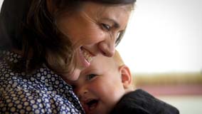 Mom smiling and holding her baby