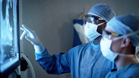 Surgeons looking at scans on screen 