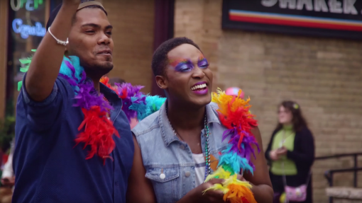 Two men wearing a rainbow boa celebrating Chicago Pride