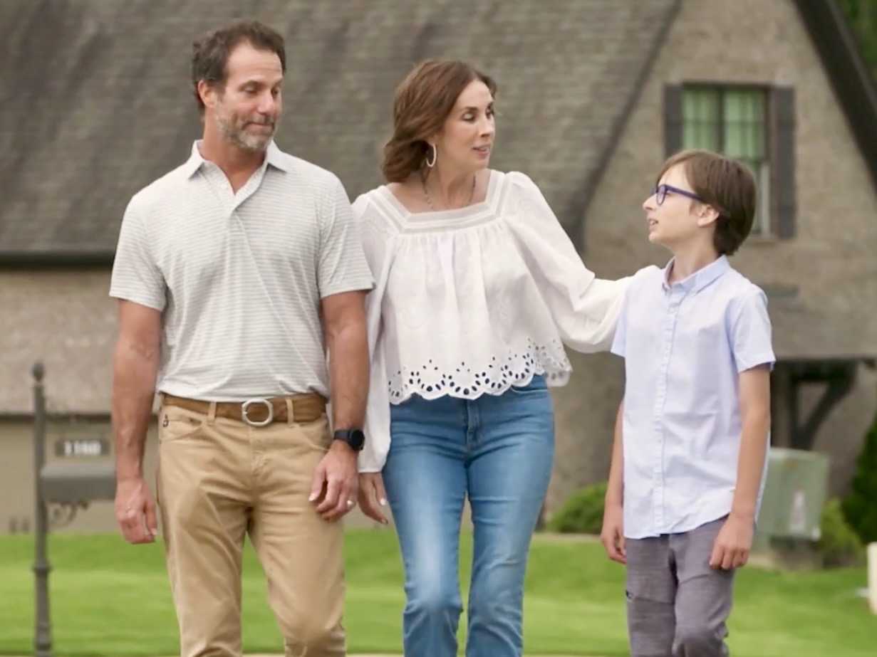 Lisa walking outdoors with her husband and son