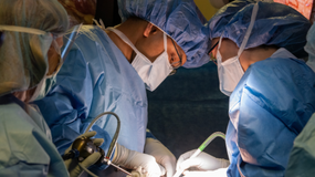 Two physicians in an operating room performing surgery.